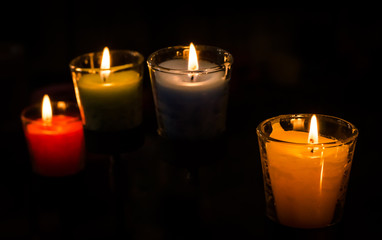 Burning candle on black background.
