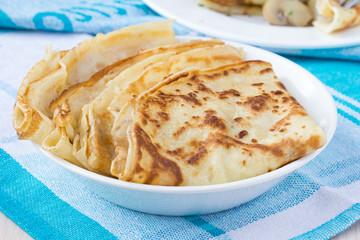 Ruddy russian pancakes folded triangle for shrovetide in bowl