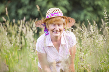 Senior Peasant Woman in Meadow smiling. Mature Friendly Lady