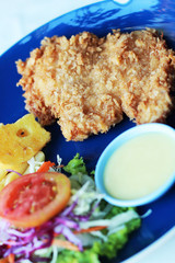 Fish steak with vegetable salad on plate.