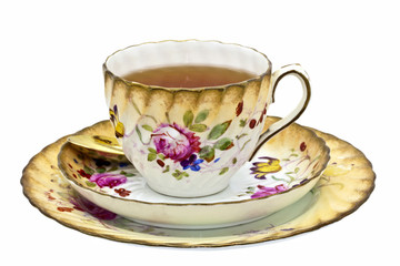 Tea in an antique china cup with saucer and dessert plate.