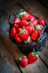 Basket of fresh strawberries on wooden background