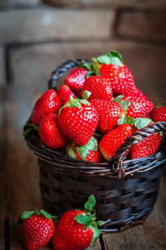 Basket of fresh strawberries on wooden background