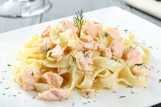 pasta con salmone piatto bianco sfondo grigio