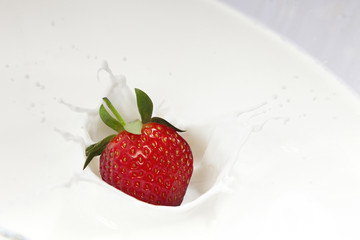drops of strawberries thrown into milk, yoghurt or cream, splash effect. health food concept, High speed sync