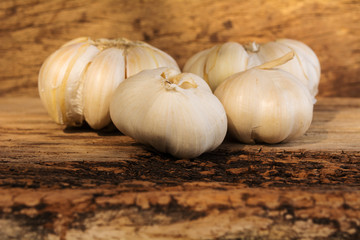 Organic garlic whole and cloves on the wooden background