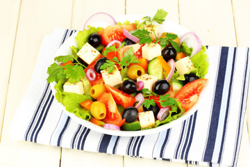 Fresh salad in plate on wooden table