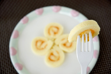 fork on orange jam sponge cake