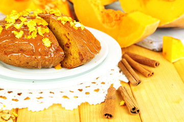 Delicious pumpkin pie on plate on wooden table close-up