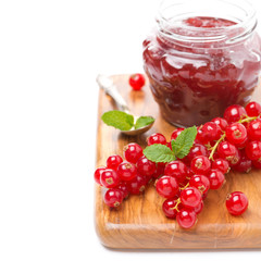 berry jam and fresh red currants on a wooden board, close-up
