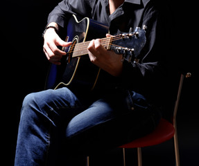 Young musician playing acoustic guitar and singing,