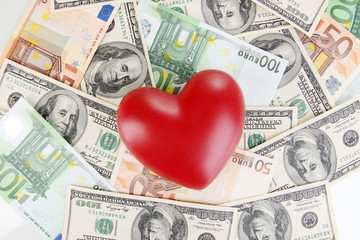 Love and money concept. Heart on European and American money
