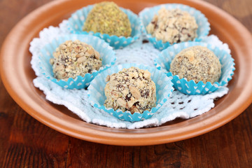 Set of chocolate candies, on plate, on wooden background