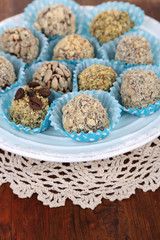 Set of chocolate candies, on plate, on wooden background