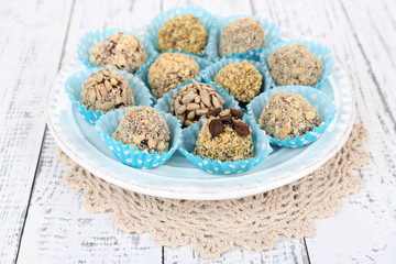 Set of chocolate candies, on plate, on wooden background