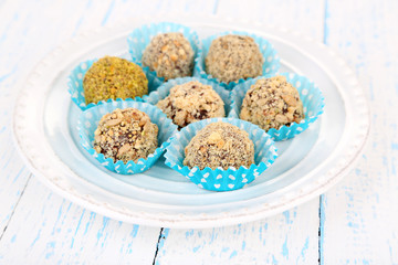 Set of chocolate candies, on plate, on wooden background