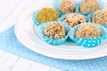 Set of chocolate candies, on plate, on wooden background