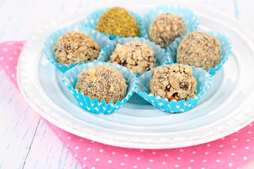 Set of chocolate candies, on plate, on wooden background