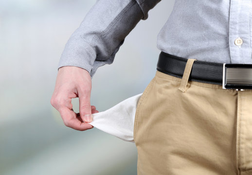 Man showing his empty pocket on bright background