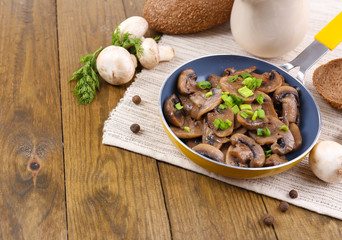 Delicious fried mushrooms in pan on table close-up
