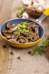 Delicious fried mushrooms in pan on table close-up