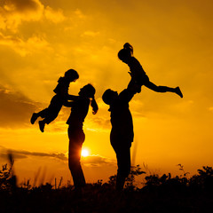 Happy  family playing on the  road in the  sunset time. Evening