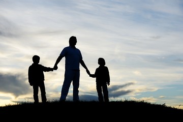 Father with sons playing on sunset meadow