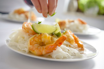 Preparation of shrimp and rice pasta meal.