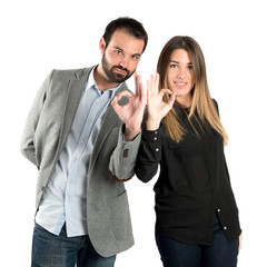 Couple making Ok sign over white background