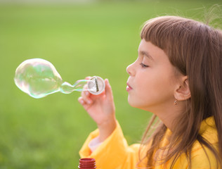 Little girl blowing soap bubbles