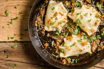 Homemade dumplings fried with onion and parsley