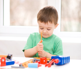 Boy is playing with tools