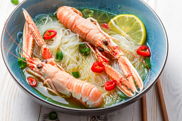 Closeup of Thai soup with scampi and noodles