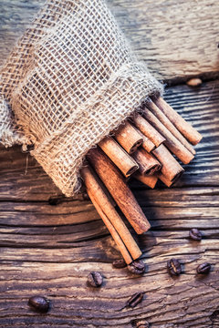 Cinnamon sticks in a burlap sack on the wooden table