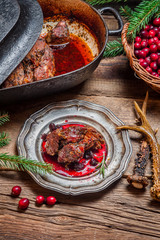 Roast venison with cranberry sauce and served in the forester lo