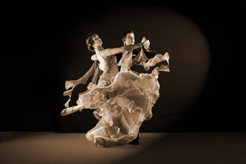 dancers in ballroom against black background