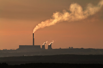 The silhouette of coal plant with thick smog
