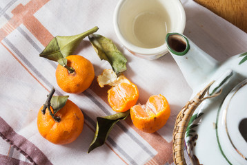 Small oranges with tea pot.