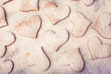 Biscuits strewed by powdered sugar on the baking paper