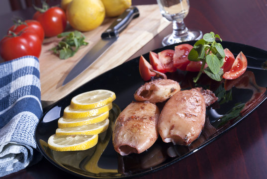 Grilled squids with sliced lemon and fresh tomato salad