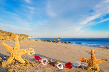 Fototapeta na wymiar Starfishes with hearts on the sandy beach