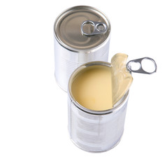 Condensed milk in tin cans over white background