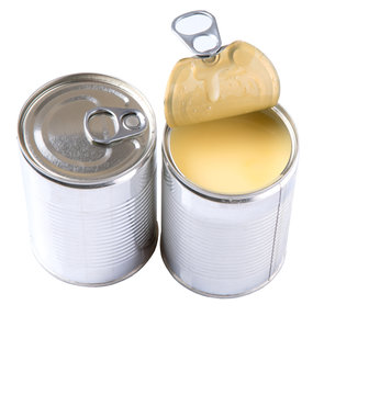Condensed milk in tin cans over white background
