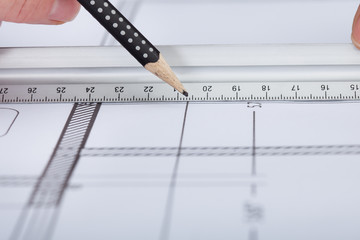 Architect Drawing On Blueprint