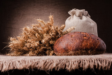 Loaf of bread and rye ears still life