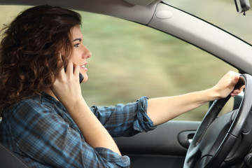 Side view of a woman driving a car and talking on the phone