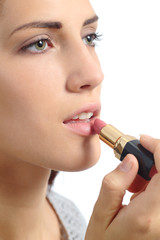 Close up of a beautiful woman applying a lipstick on lips