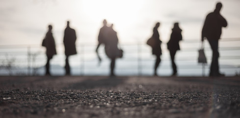 blurred silhouettes of people standing in bright sky