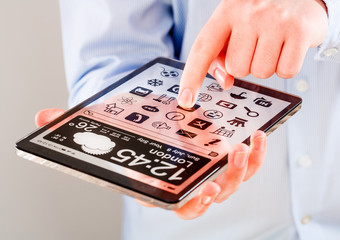 Tablet with transparent screen in human hands.