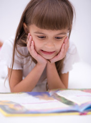 Naklejka premium Little girl is reading a book